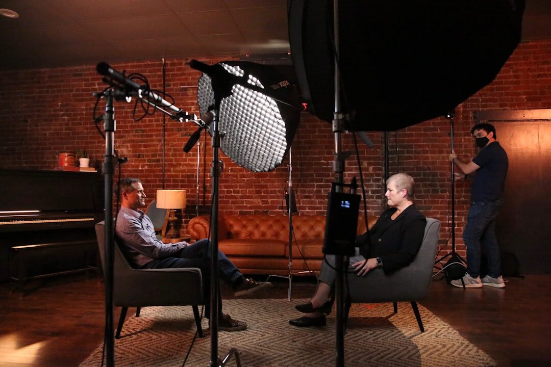 Video production crew setting up camera and lighting equipment in a studio