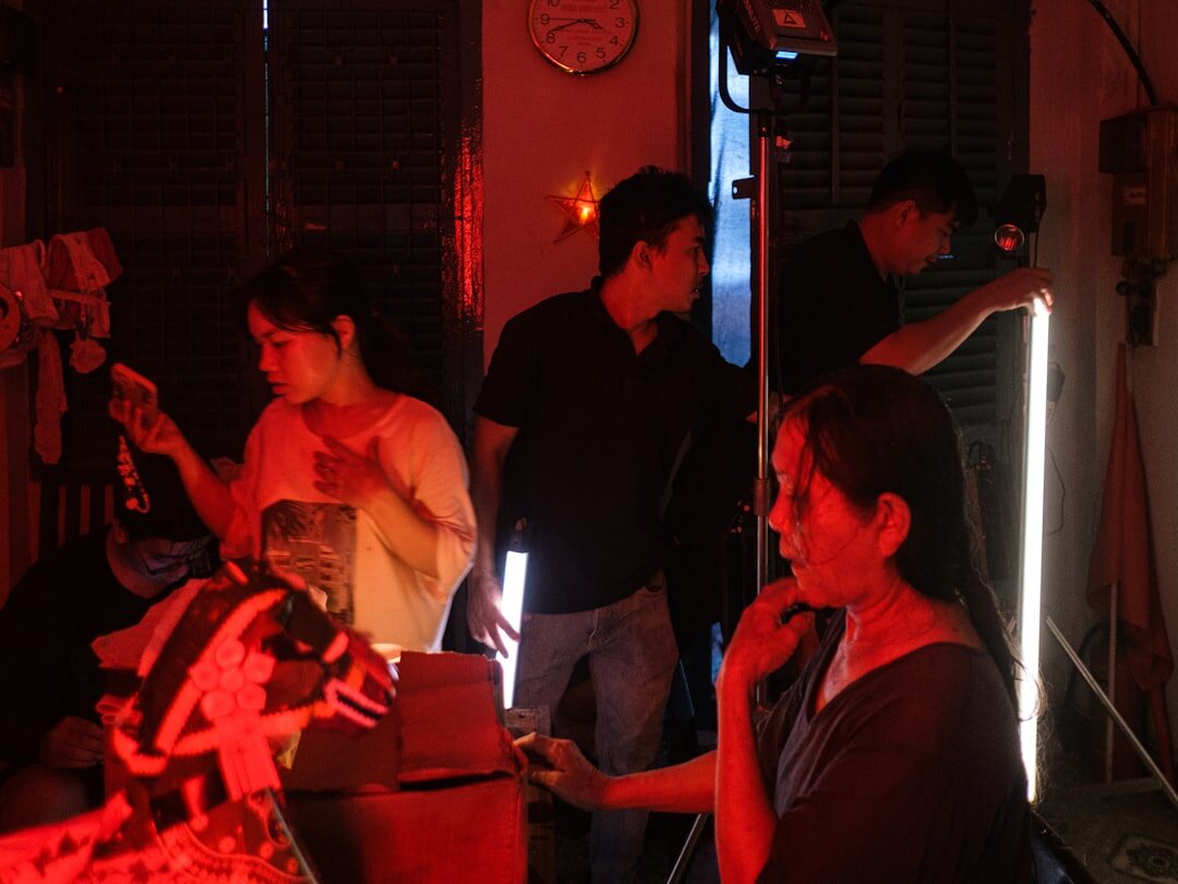 Director adjusting studio lighting around a speaker on set